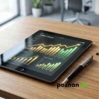 Nowoczesny Tablet Z Wykresami Sprzedaży Leżący Na Drewnianym Biurku Obok Filiżanki Kawy I Okularów.