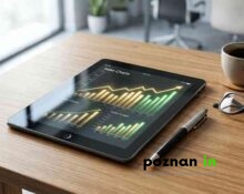 Nowoczesny Tablet Z Wykresami Sprzedaży Leżący Na Drewnianym Biurku Obok Filiżanki Kawy I Okularów.