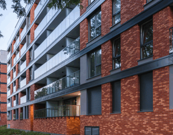 Nowoczesny budynek mieszkalny z elewacją z czerwonej cegły ceramicznej i przeszklonymi balkonami