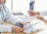 Lekarz omawia wyniki badań diagnostycznych z pacjentem podczas konsultacji stomatologicznej.