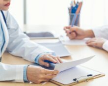 Lekarz omawia wyniki badań diagnostycznych z pacjentem podczas konsultacji stomatologicznej.