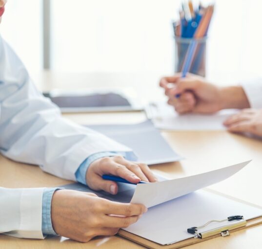 Lekarz omawia wyniki badań diagnostycznych z pacjentem podczas konsultacji stomatologicznej.