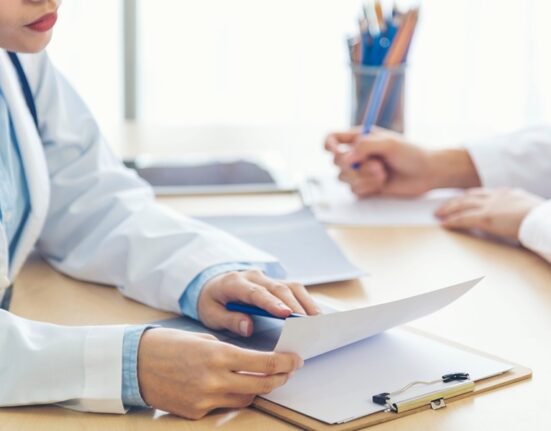 Lekarz omawia wyniki badań diagnostycznych z pacjentem podczas konsultacji stomatologicznej.